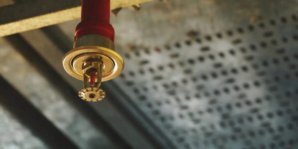 Nước từ đầu sprinkler được phun theo dạng hình nón, bao phủ toàn khu vực cháy